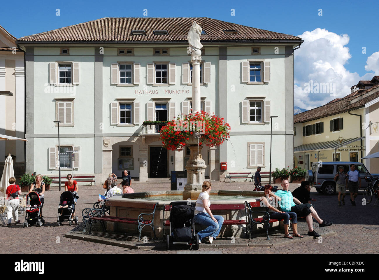Rathaus von Kaltern an der Südtiroler Wein-Route mit dem Marienbrunnen auf dem Marktplatz. Stockfoto