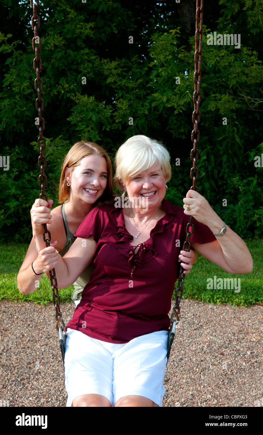 Midwest-Mutter und Tochter spielen im Park im Swing und umarmt spielen Stockfoto