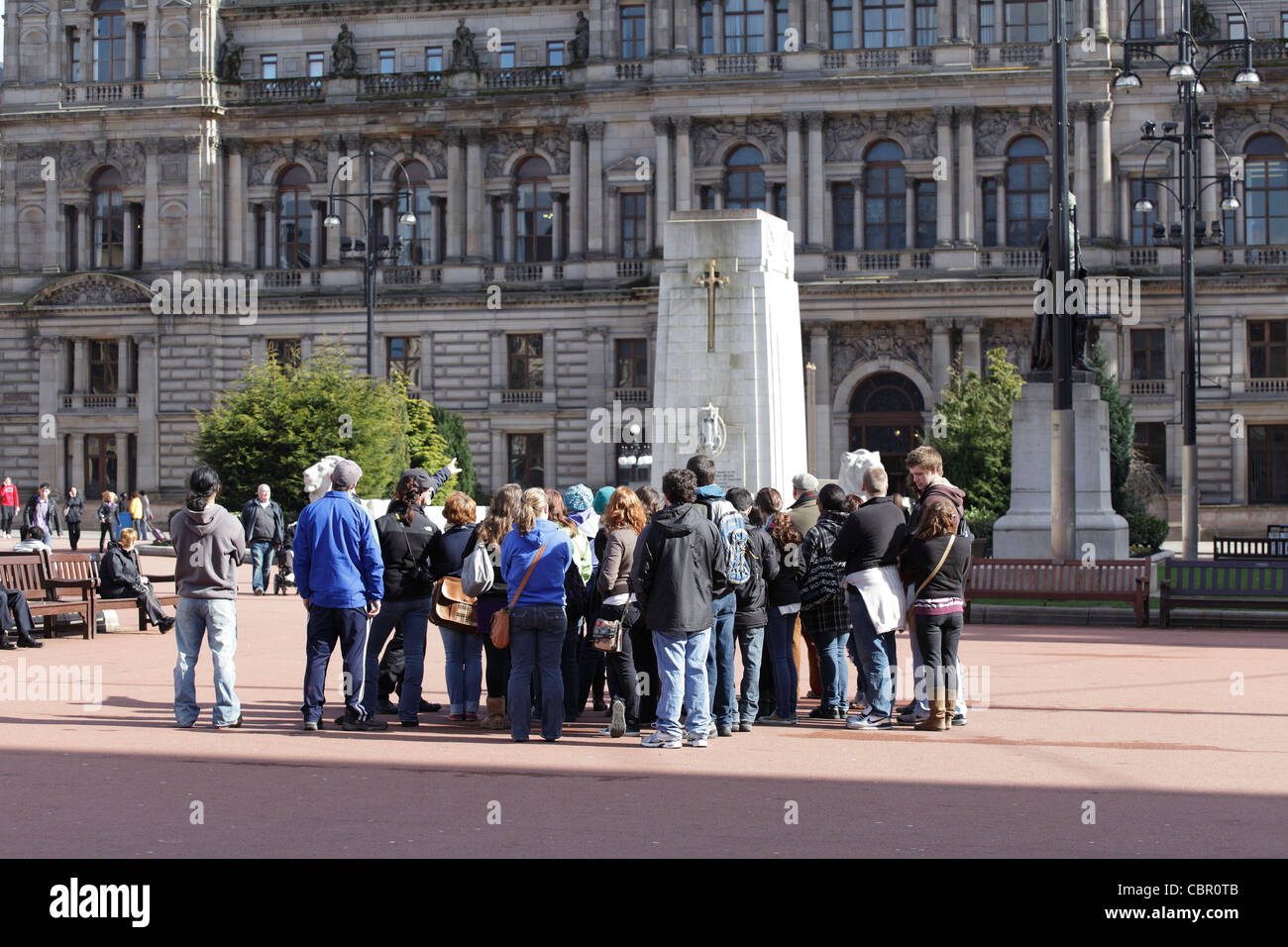 Eine Reisegruppe und Reiseführer auf dem George Square im Stadtzentrum von Glasgow, Schottland, Großbritannien Stockfoto