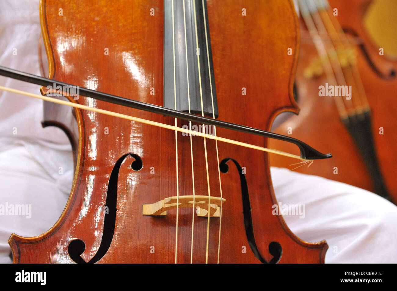 Cello auf Musiker Knie Stockfoto