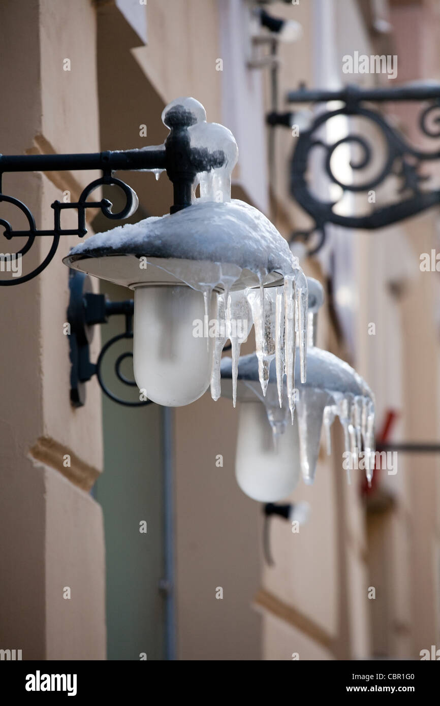 zwei Straßenlaternen mit Eiszapfen hängen an Hauswand Stockfoto