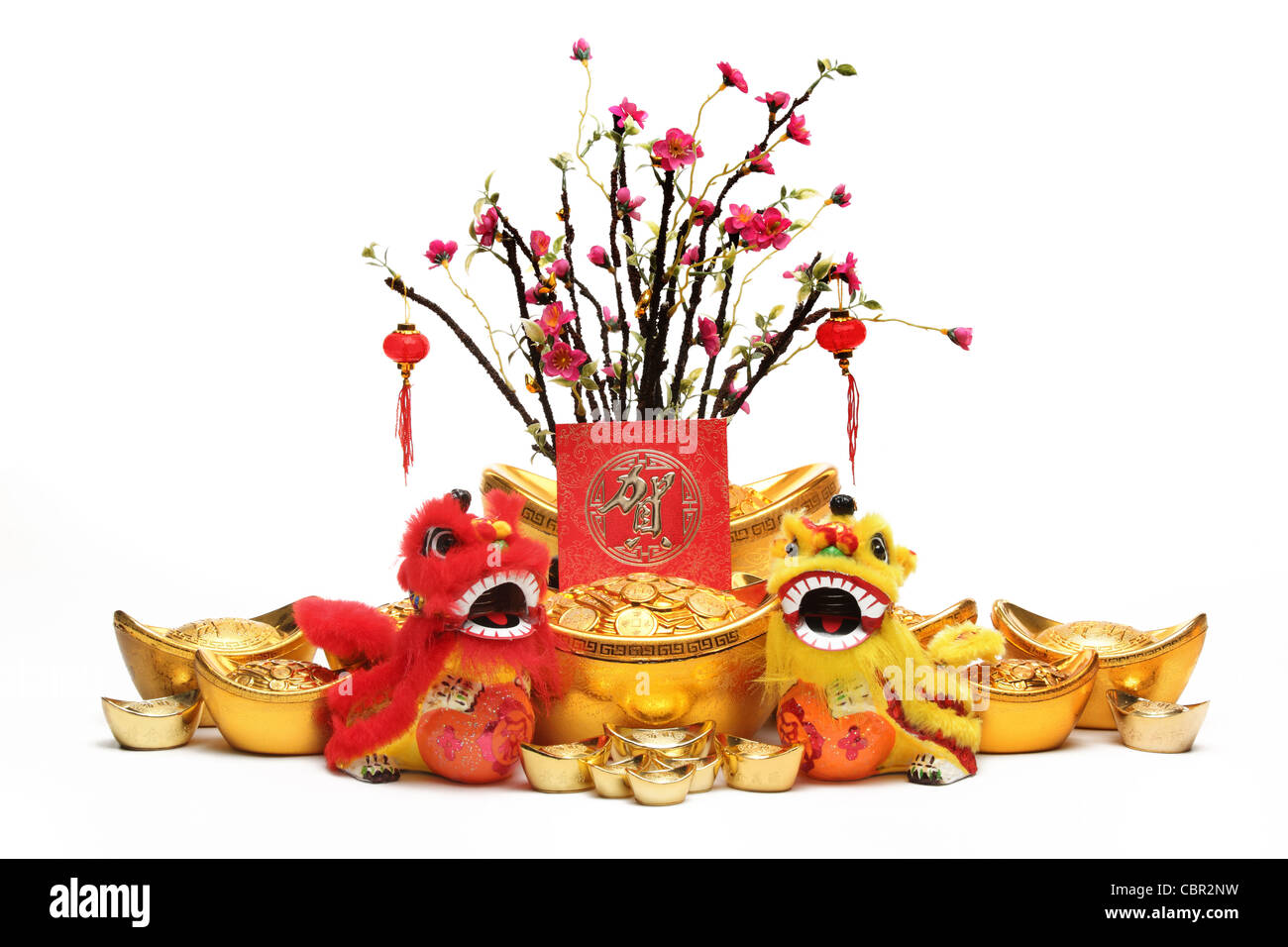 Chinese New Year Dekorationen--traditionelle tanzende Löwen, Goldbarren, rote Päckchen und Pflaumenbaum. Stockfoto