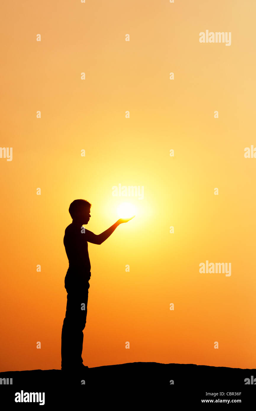 Indischen Mann stand halten die Sonne. Silhouette. Indien Stockfoto