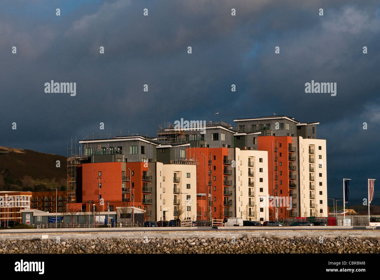 Neues Appartementhaus in Süd-Wales Swansea, sonnendurchfluteten vor einem dunklen Himmel. Stockfoto