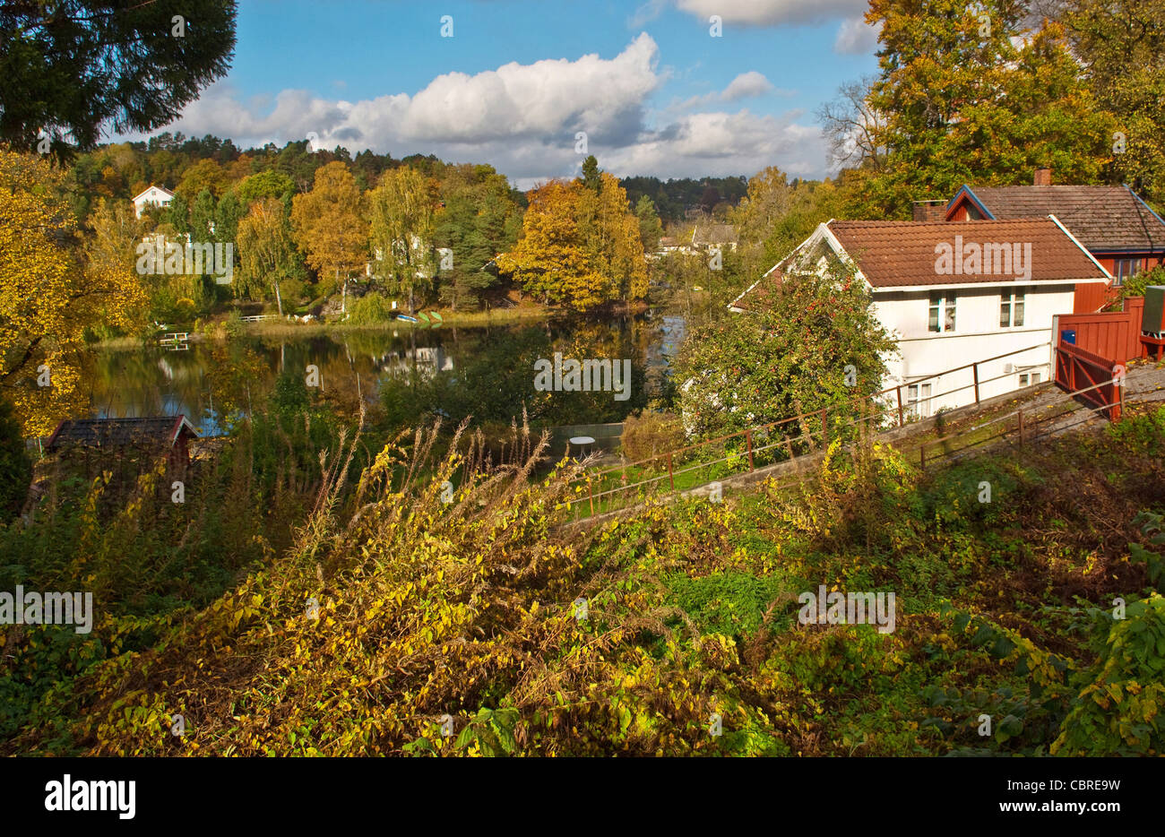 Traditionelle norwegische Häuser neben einem idyllischen See in der Nähe von Arendal Stockfoto