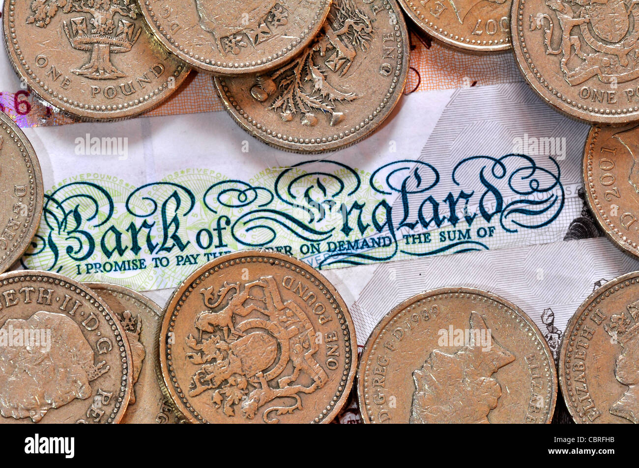 Sterling-Währung - Pfund-Münzen und eine fünf-Pfund beachten Sie UK Stockfoto