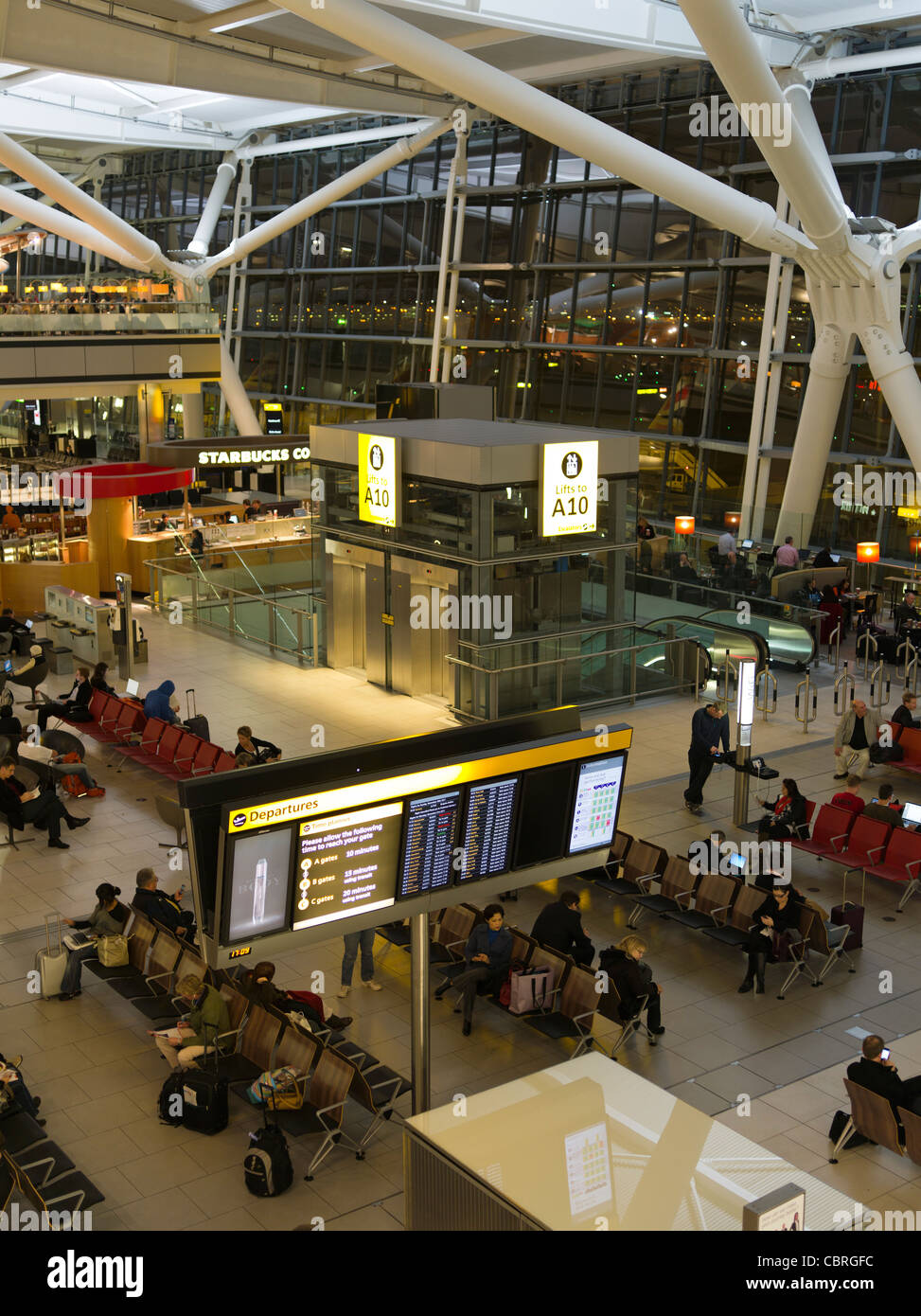 dh Terminal fünf 5 Abflüge FLUGHAFEN HEATHROW LONDON Passagiere, die in der Abflughalle des internationalen innenraums der britischen Bevölkerung warten Stockfoto