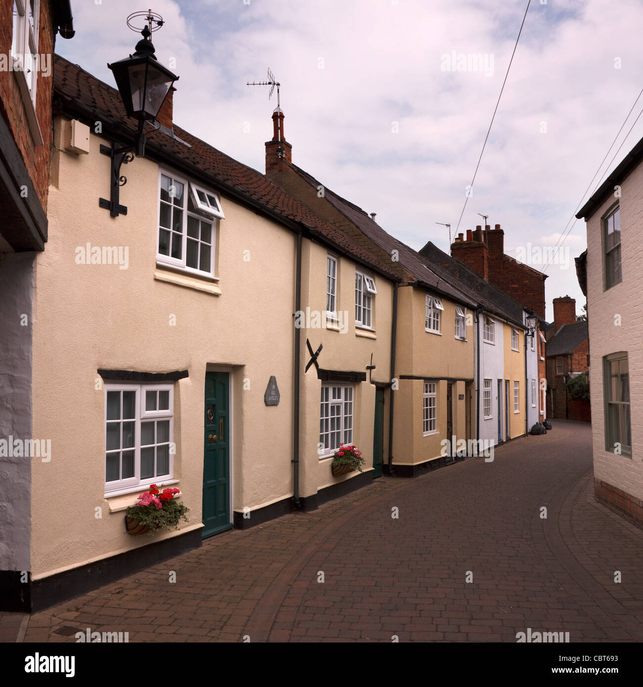 Terrassenförmig angelegten Reihe von schönen alten englischen Cottages in schmalen Seitenstraße, gemalt Deans Street, Oakham, Rutland, England, UK Stockfoto
