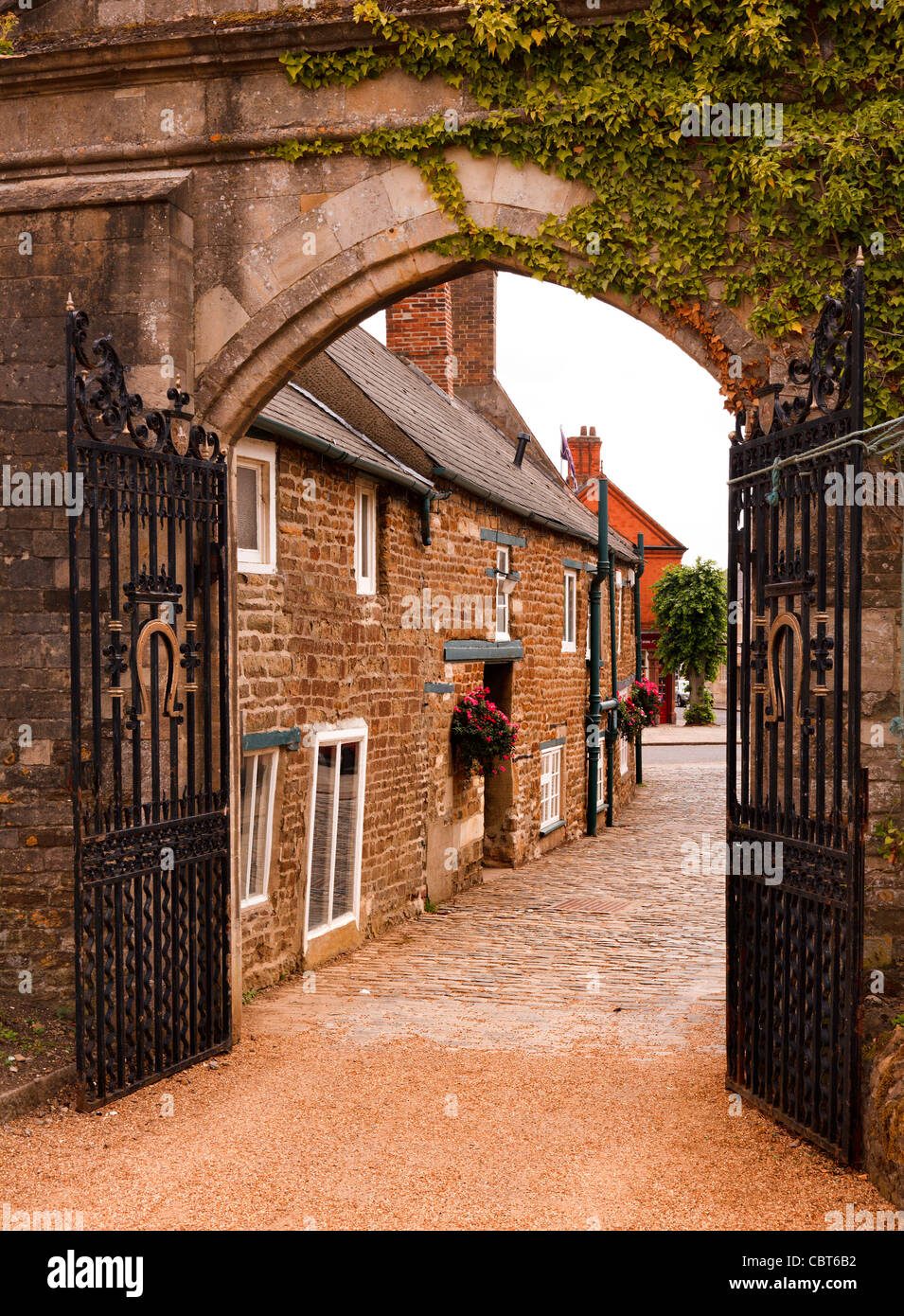 Stein-Bogen und Schmiedeeisen Tore am Eingang zum Gelände der großen Halle Oakham Castle, Oakham, Rutland, England, UK Stockfoto