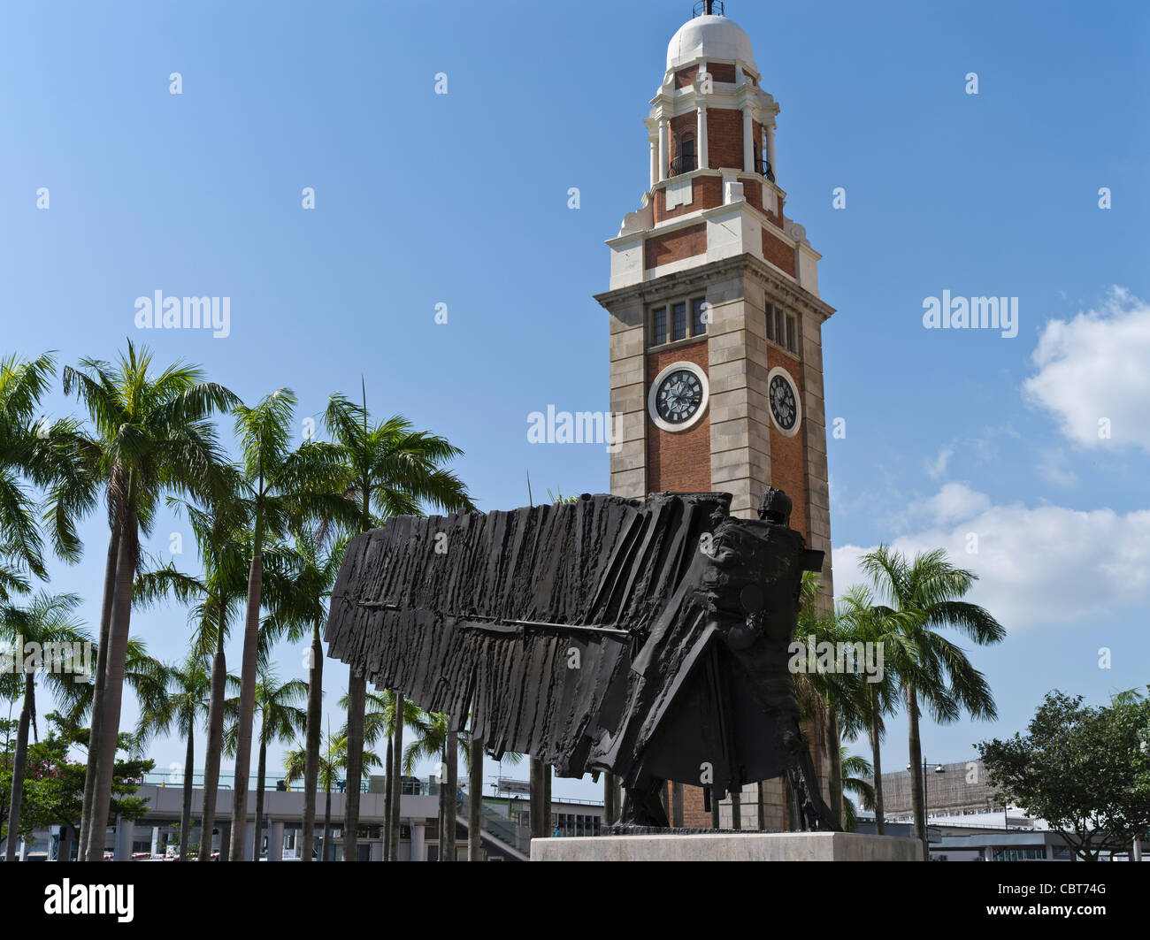 Dh clocktower Tsim sha Tsui Kowloon HONG KONG Der fliegende Franzose Skulptur von Cesar und Old Clock Tower Gebäude modern Stockfoto