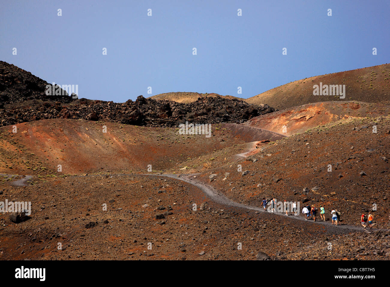 Eine Gruppe von Touristen zu Fuß in Richtung der aktiven Kraters auf Nea ("neu") Kameni Insel, im Herzen der Caldera von Santorin. Stockfoto