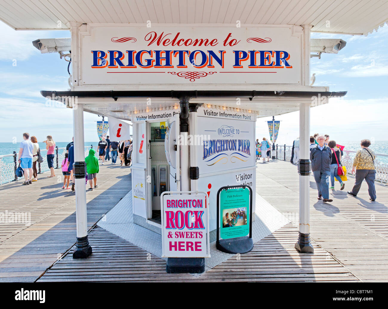Menschen auf Urlaub und Ferien sitzen, entspannen, Wandern und Vergnügen sich auf der Pier von Brighton Promenade. Stockfoto