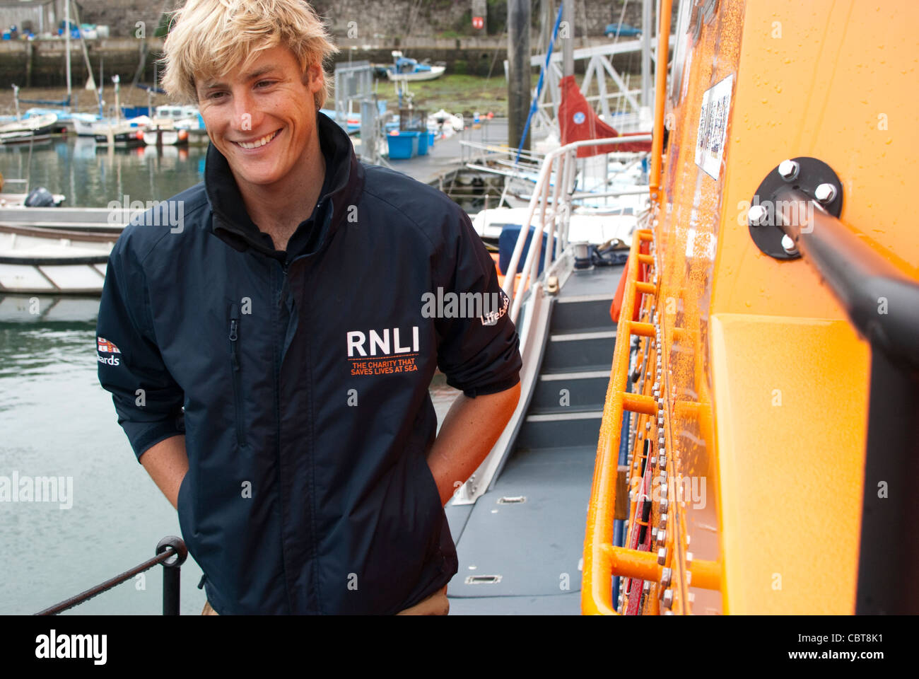 Ein RNLI-Mitglied geht und auf ein Lfeboat Lächeln. Stockfoto