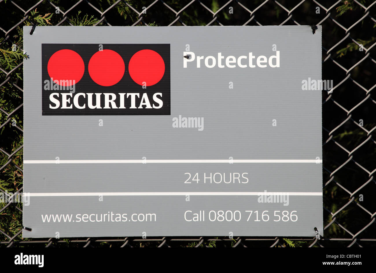 Ein Hinweis angebracht, ein Maschendrahtzaun, die darauf hinweist, dass ein Industriestandort von Securitas geschützt ist. Stockfoto