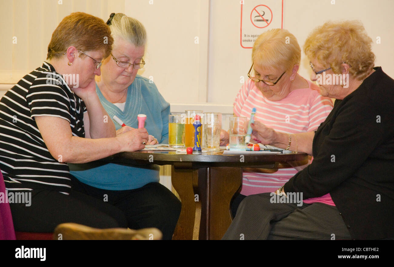 Elderley Damen im Club Bingo spielen Stockfoto