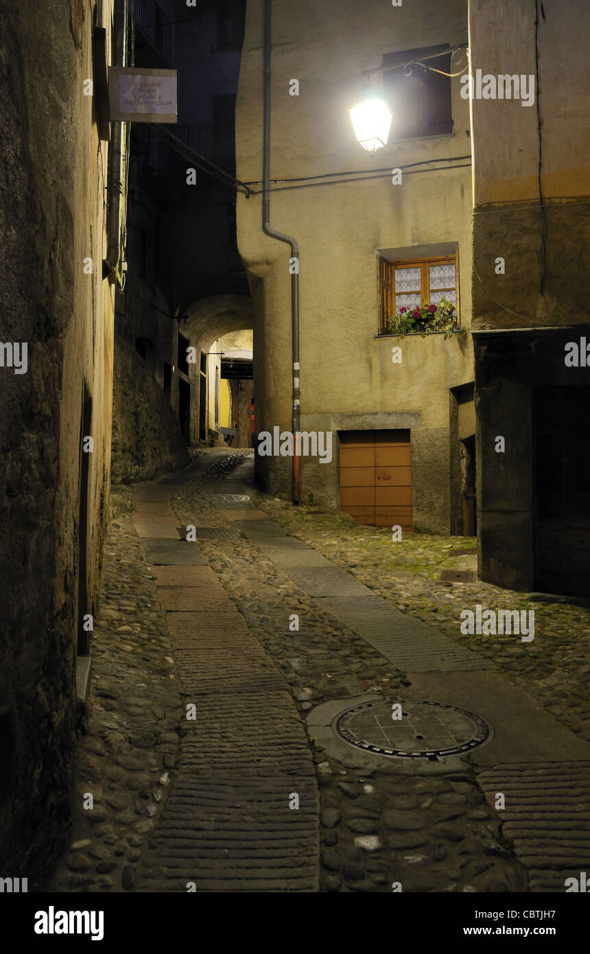 Dunkle Alley beleuchtet von Single Street Light oder Lampe bei Nacht, Tende Altstadt, Roya Valley, Alpes-Maritimes, Frankreich Stockfoto