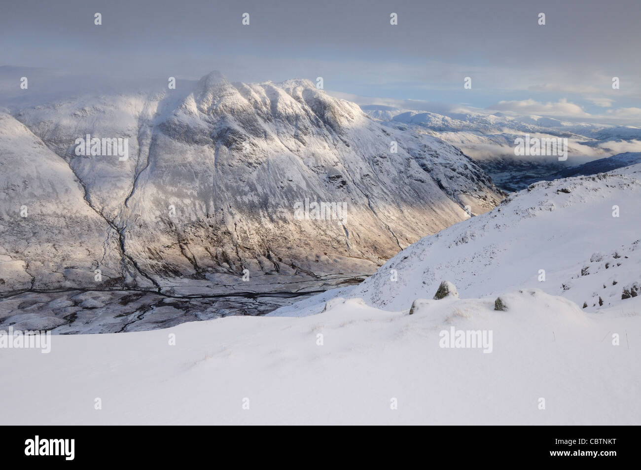 Brechen von Sonnenlicht auf die Langdale Pikes im Winter im englischen Lake District Stockfoto