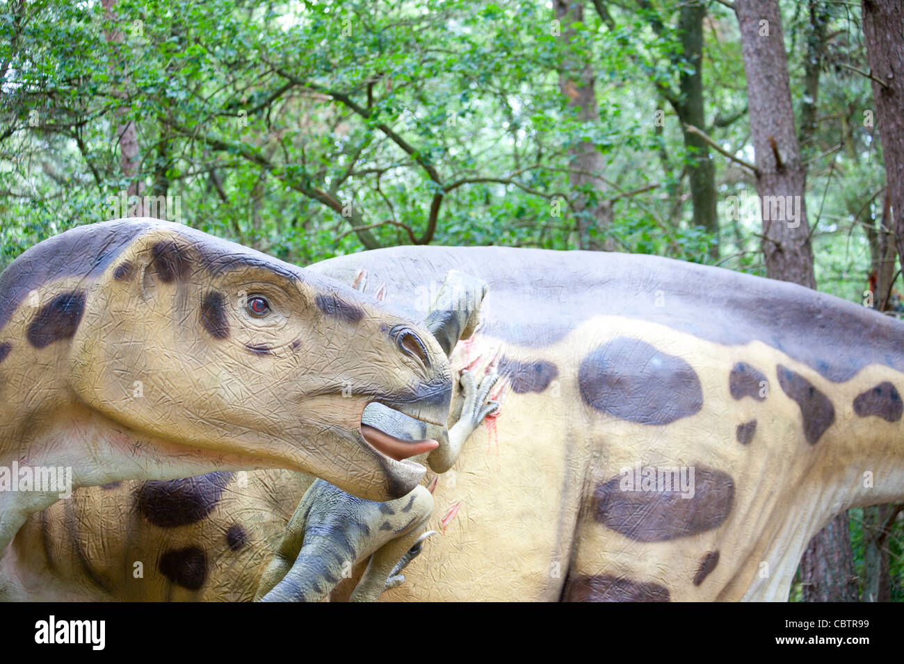 Iguanodon und Deinonychus Kämpfe im Wald Stockfoto