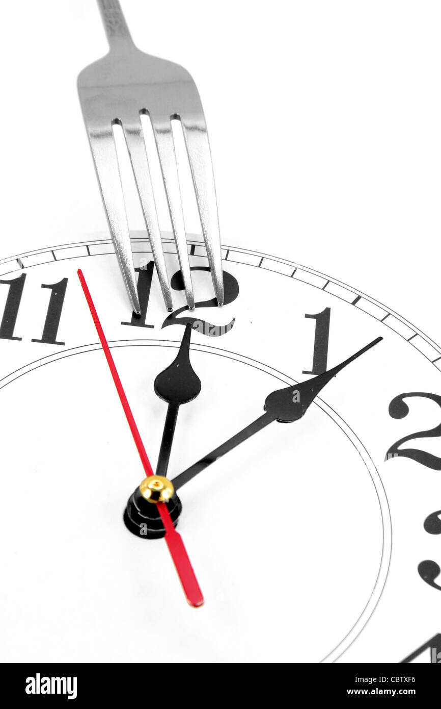 Gabel und Wand Uhr mit weißem Hintergrund, Konzept der Mittagszeit Stockfoto