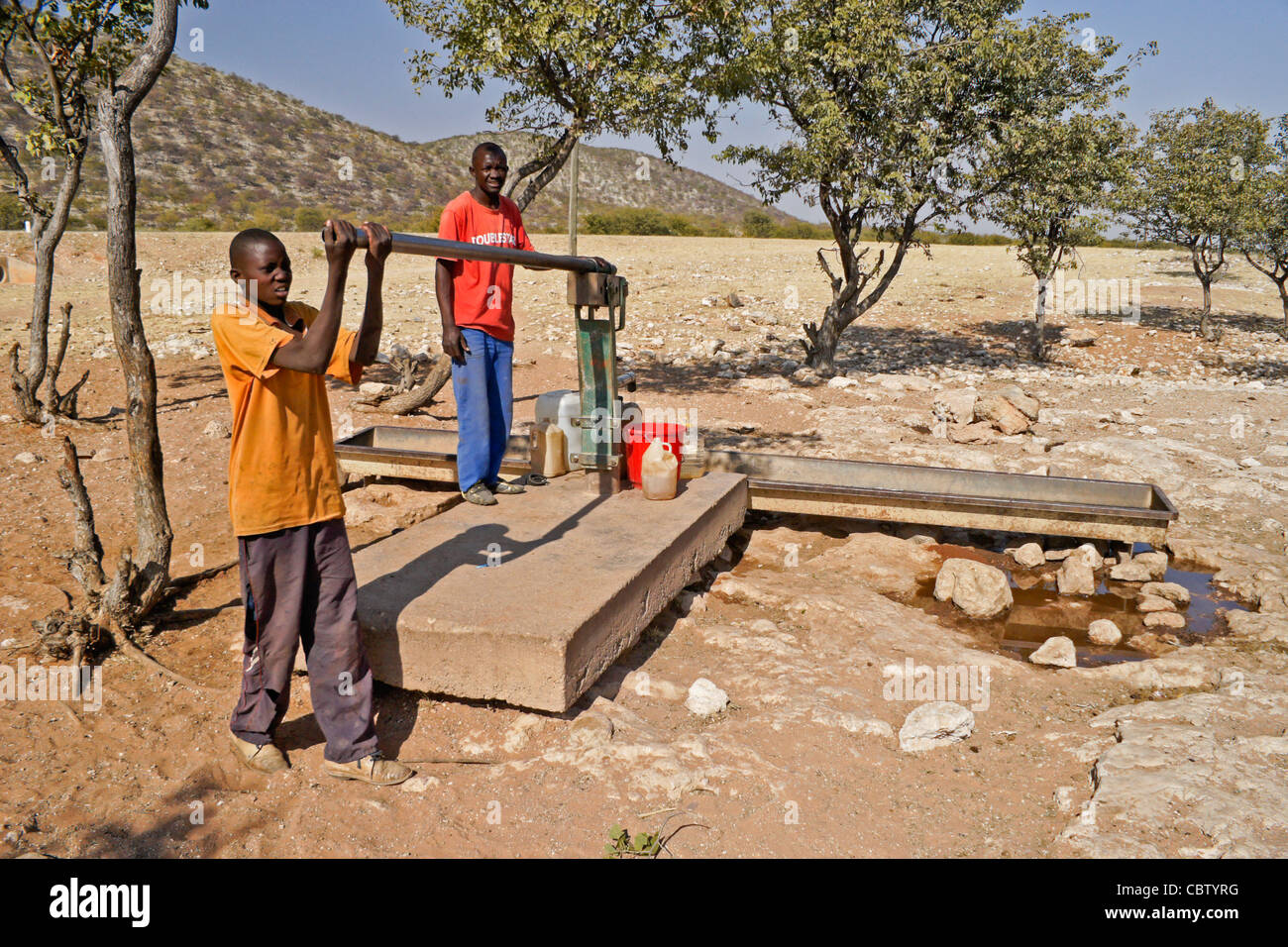 Herero Jungs immer Wasser von öffentlichen Pumpe, Damaraland, Namibia Stockfoto