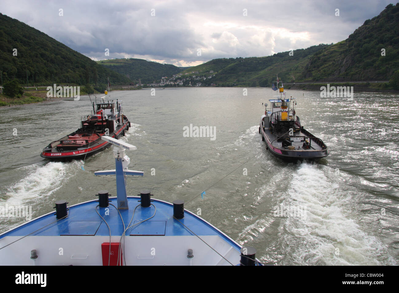 Schlepptau Boote verleihen Unterstützung zu einem Fluss Kreuzfahrt Boot auf dem Rhein stromaufwärts der Loreley, Deutschland Stockfoto