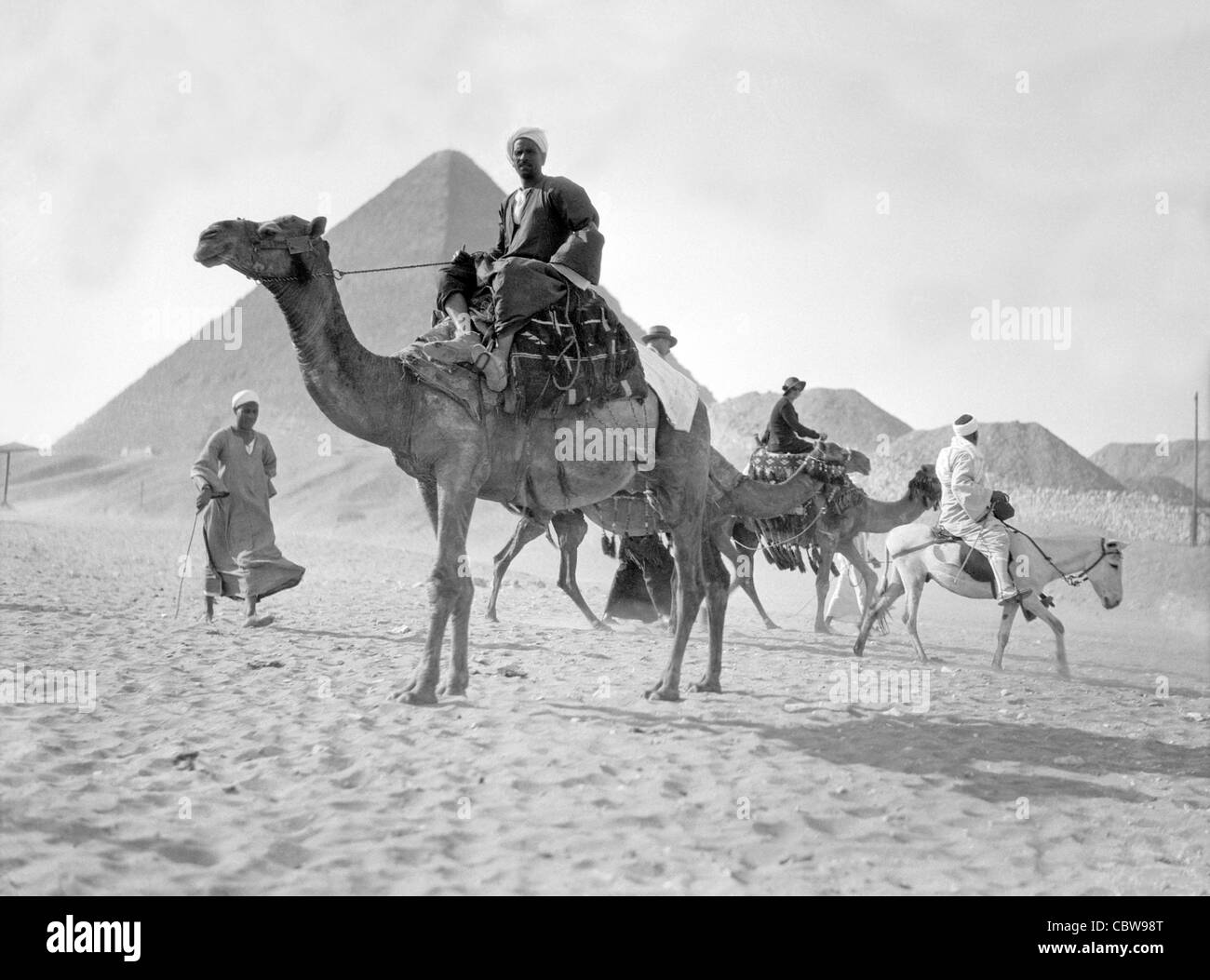 Ägypten. Pyramiden von Gizeh. Kamele & Fahrer in der Nähe der großen Pyramide geschaffen zwischen 1934 und 1939 Stockfoto