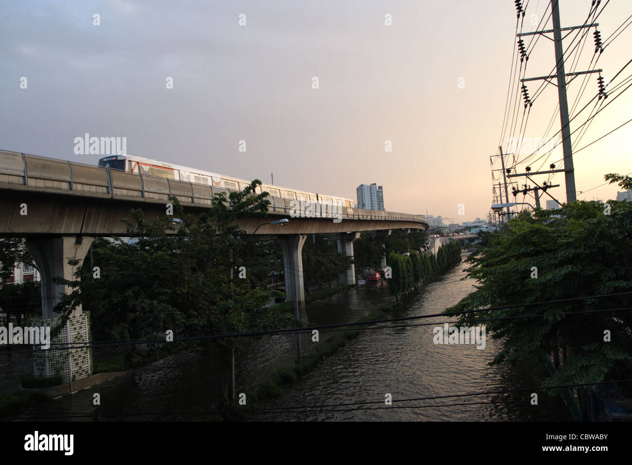 BTS Sky Train über Hochwasser auf Straße in Bangkok Stockfoto