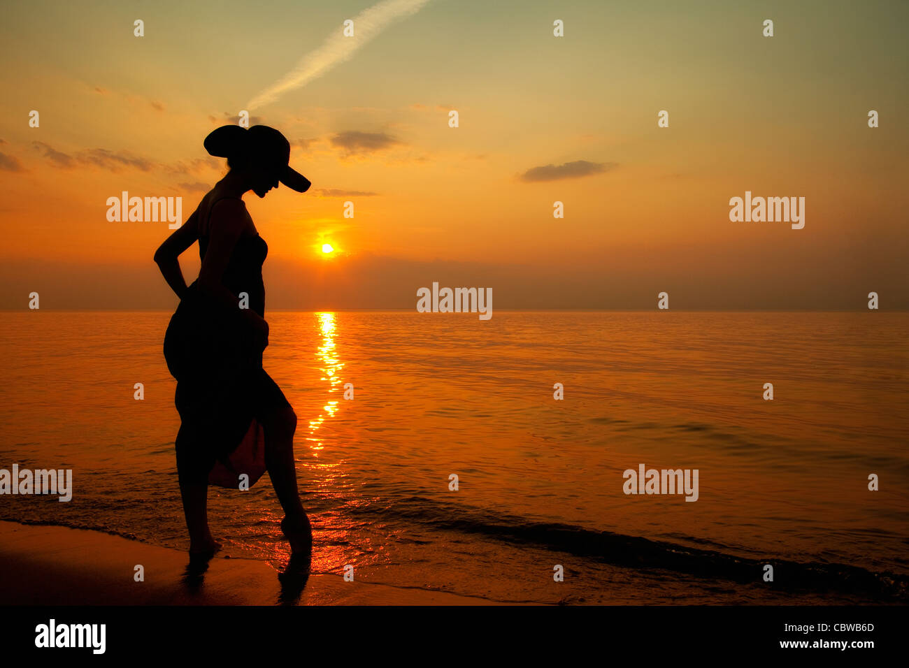 Frau mit Hut auf Indiana Dunes Beach bei einem wunderschönen Sonnenuntergang Stockfoto