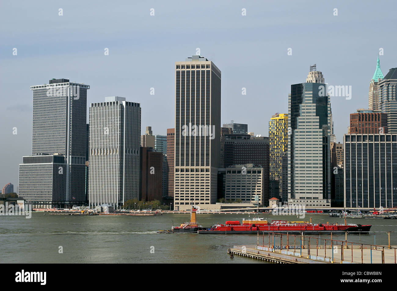 Blick auf Lower Manhattan von der Brooklyn Heights Promenade als Boot geht in den East River. Stockfoto