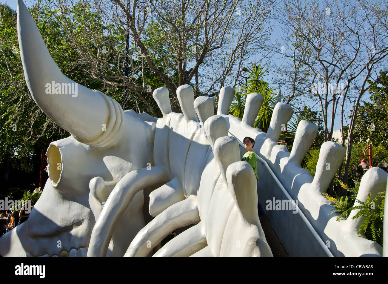 Fivels Playland Kinderspielplatz mit jungen Klettern Rückseite riesige Kuh Skelett bei Universal Studios Orlando Florida Stockfoto