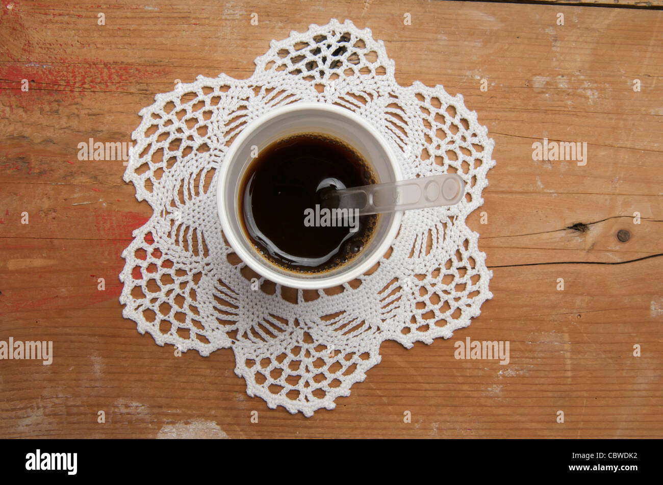 Verfügbare Kaffeetasse auf einer Unterlage. Stockfoto