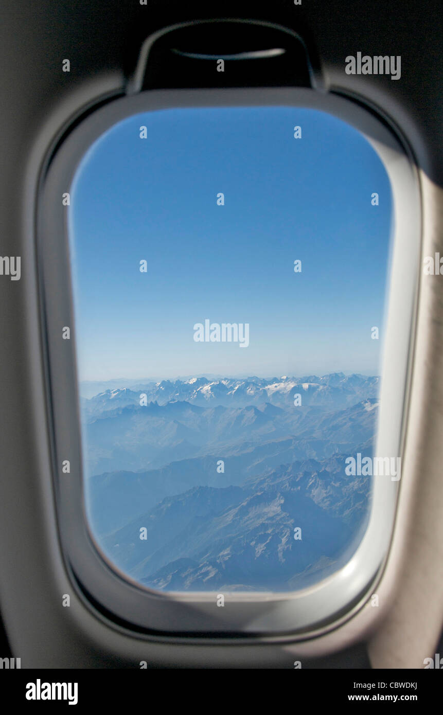 Nahaufnahme der Fenster Flugzeug mit Blick auf eine Reihe von Bergen. Stockfoto