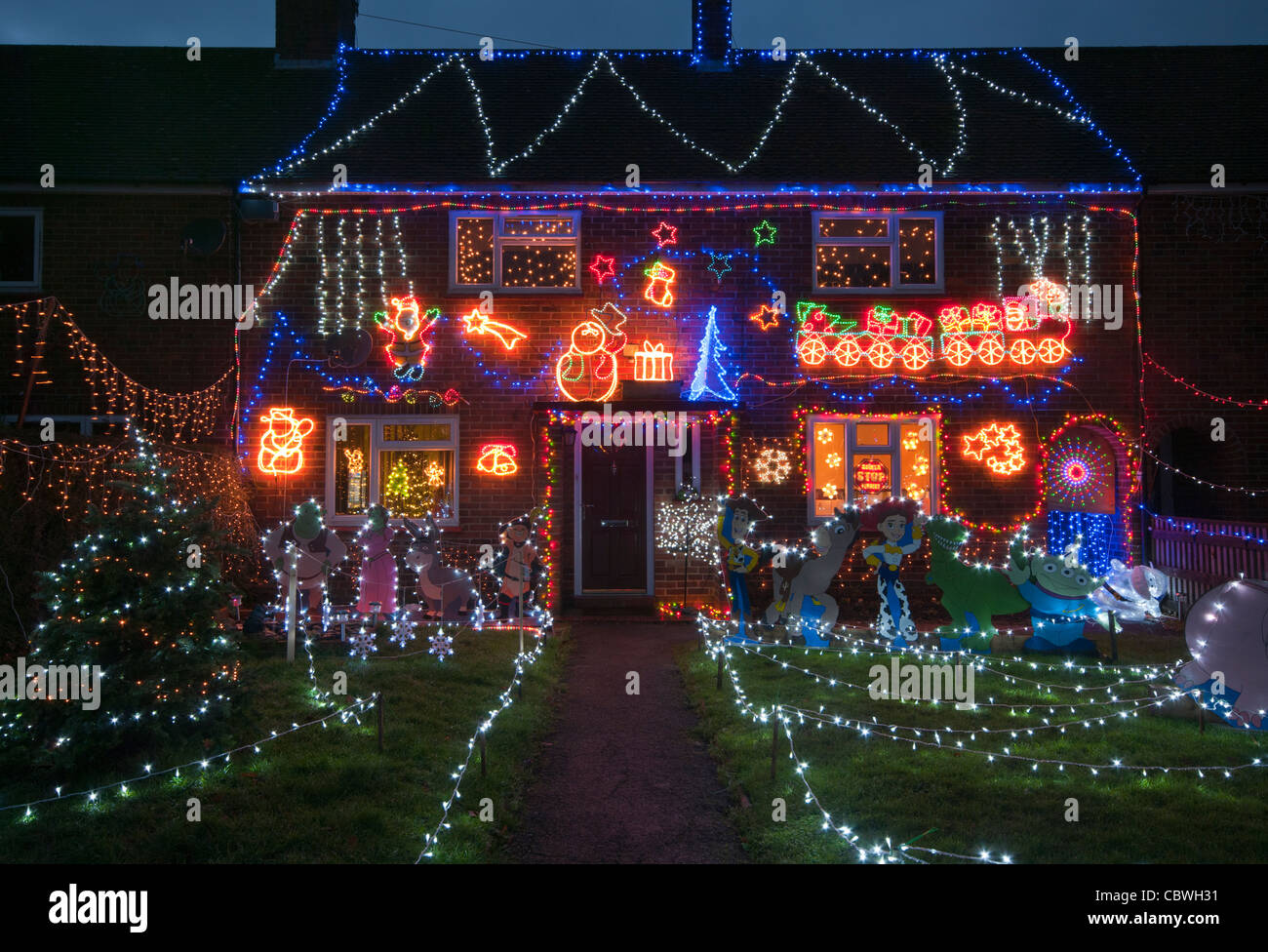 Fassade eines Hauses Lit Up mit Weihnachtsbeleuchtung in Dämmerung Home Unterkunft Weihnachten Dekorationen nachts beleuchtet Stockfoto