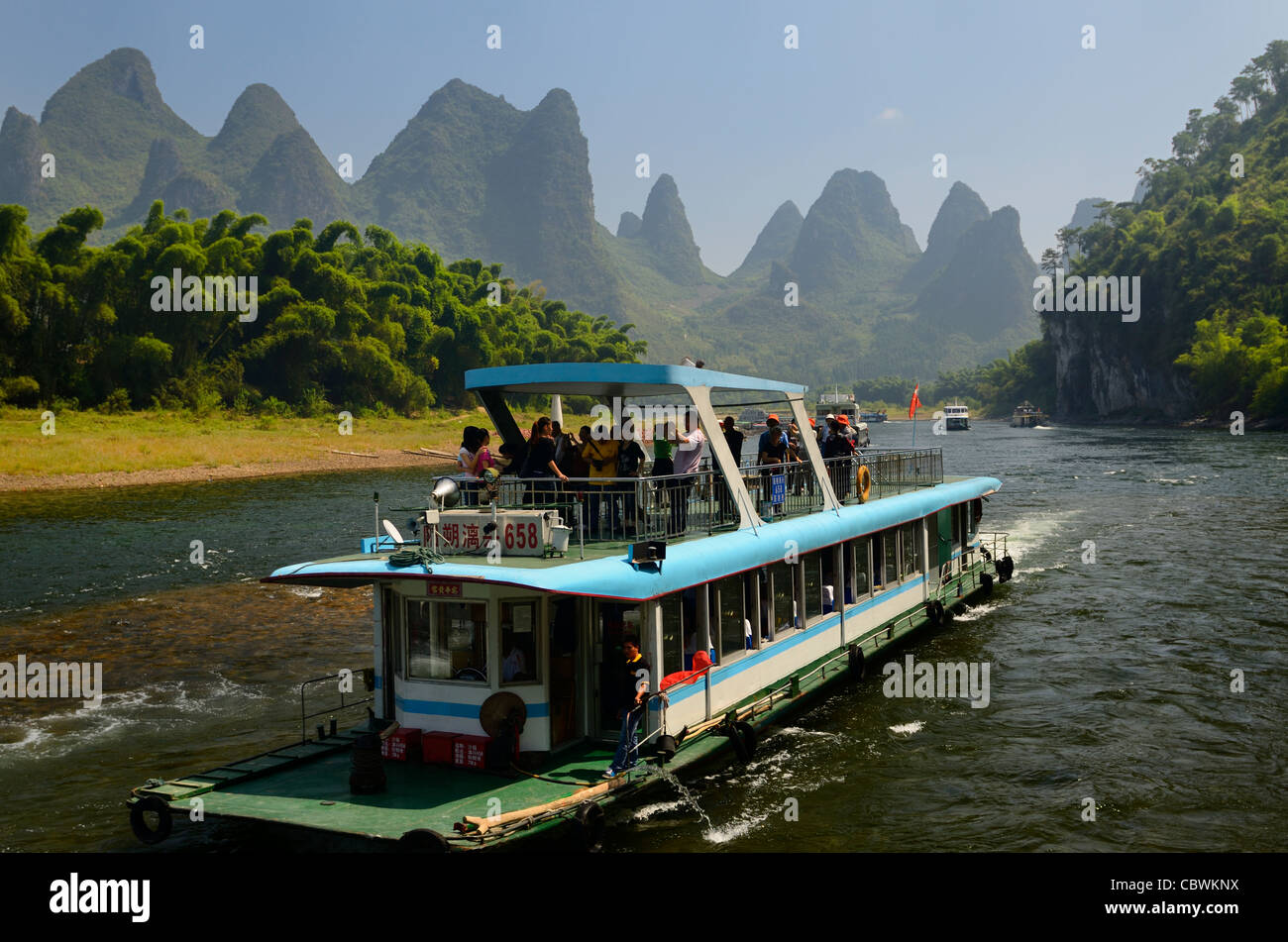Tour Bootsfahrt auf dem Li-fluss mit Bambus Wald und diesig Karst peaks Volksrepublik China Stockfoto
