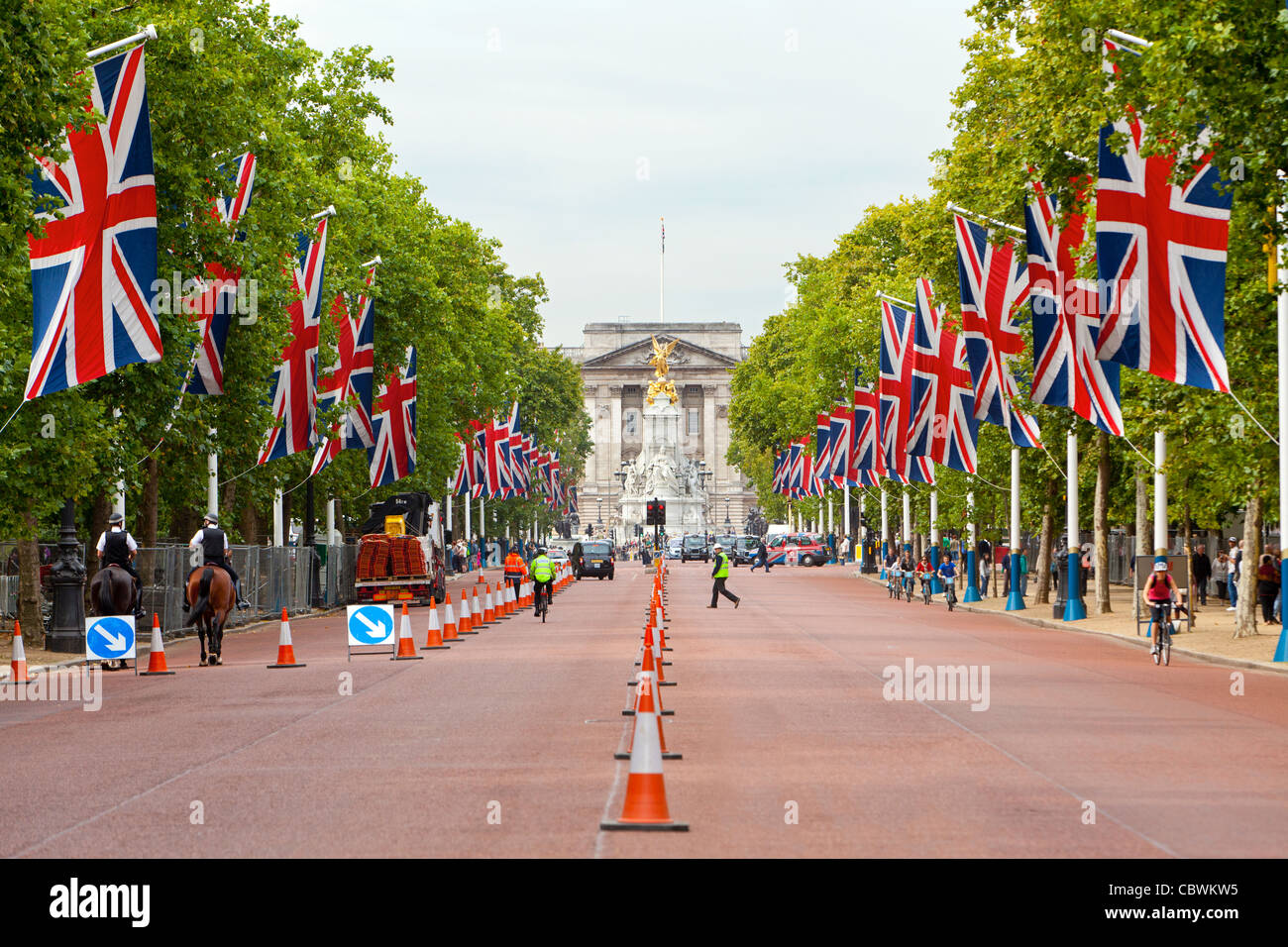 Autos und Fahrräder fahren und Fußgänger zu Fuß auf der Mall vor Buckingham Palace. Stockfoto