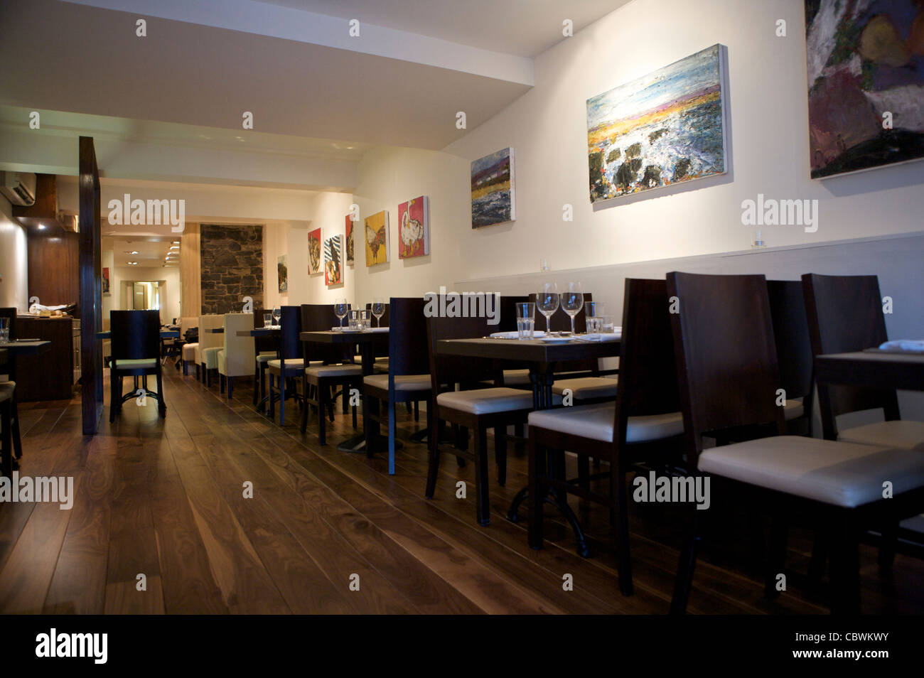 Interieur mit Stühlen und Tischen an der Wand entlang. Stockfoto