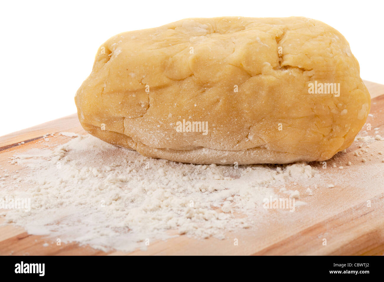 eine Kugel aus Teig geknetet, für einen Kuchen auf Holzbrett mit Weizenmehl, isoliert auf weiss Stockfoto