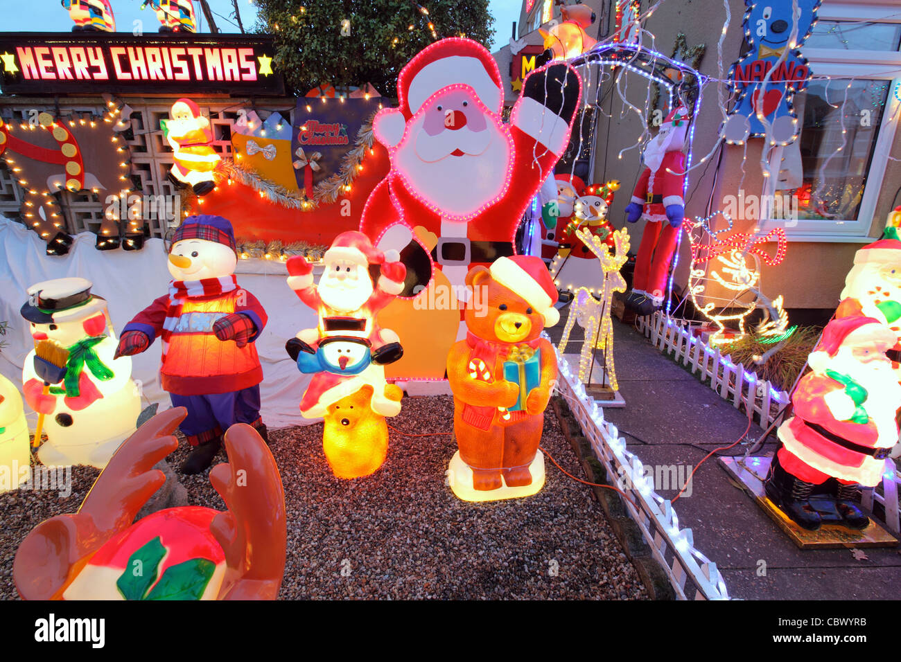 Glühende beleuchtet bunt Kunststoff Kitsch Weihnachtsschmuck im Garten s UK  Doppelhaushälfte, Suffolk, England Stockfotografie - Alamy