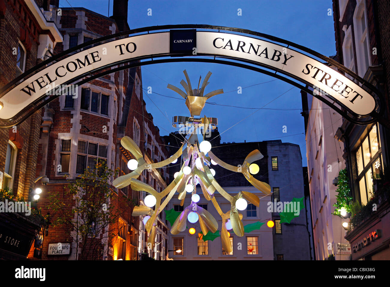 Weihnachtsbeleuchtung und Dekorationen geschmückt wie Holly und Mistel in der Carnaby Street in London Stockfoto