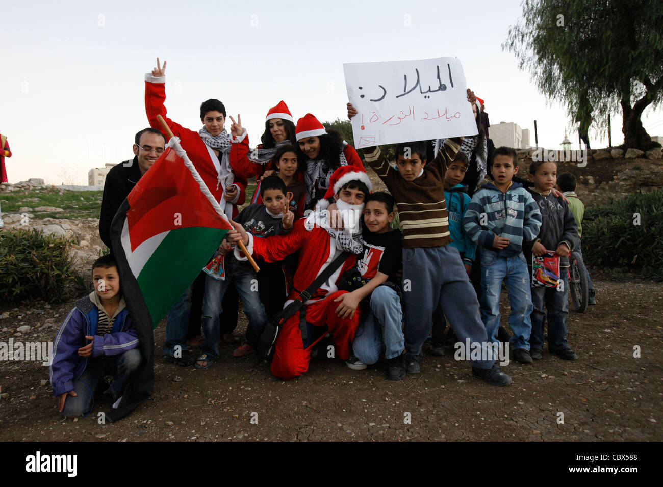 Israelische Araber und Palästinenser im Weihnachtsmann-Outfit halten die Flagge von Palestini9an, während sie während einer Demonstration gegen israelische Besatzung und Siedlungsaktivitäten im Sheikh Jarrah-Viertel in Ostjerusalem, Israel, für einen Fotografen posieren. Das palästinensische Viertel Sheikh Jarrah ist derzeit das Zentrum einer Reihe von Eigentumsstreitigkeiten zwischen Palästinensern und rechtsgerichteten jüdischen Israelis. Einige Häuser wurden nach einem Gerichtsurteil von israelischen Siedlern besetzt. Stockfoto