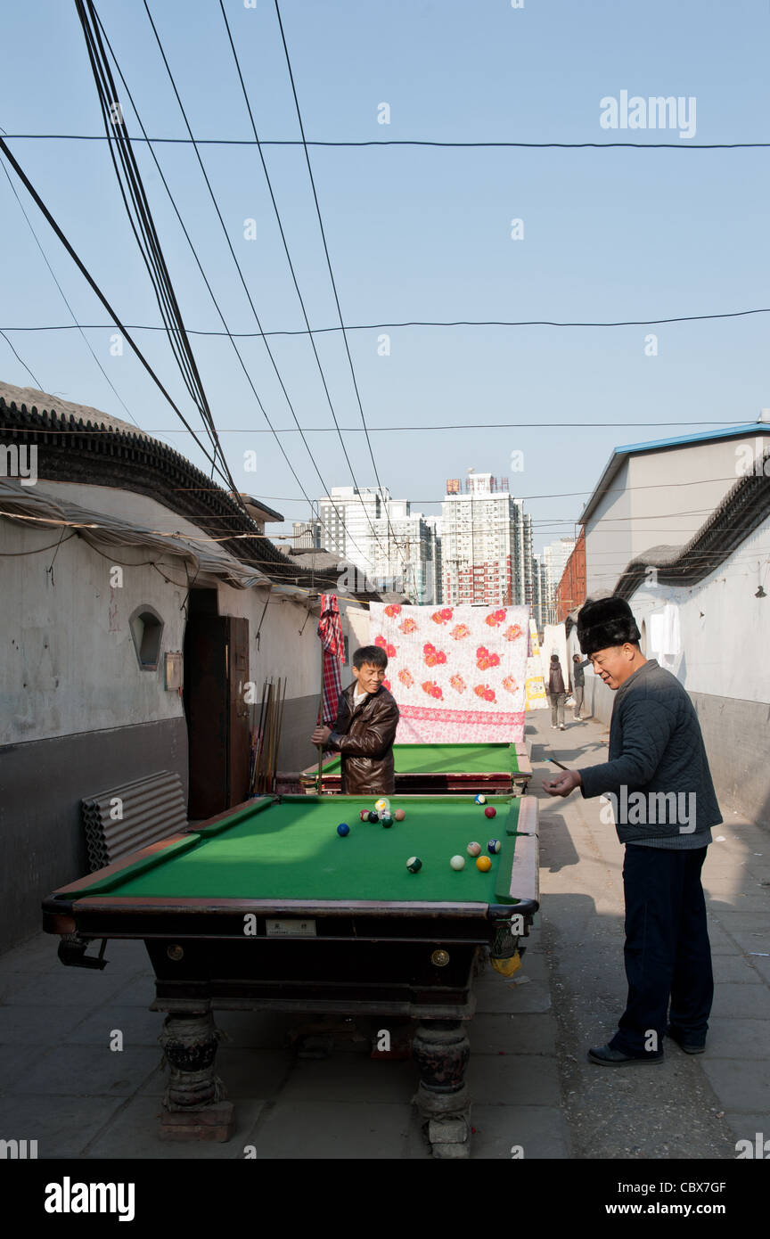 Xiadian, Beijing. Männer spielen Pool in einem Armenviertel mit in den Hintergrund Beijing Central Business District. Stockfoto