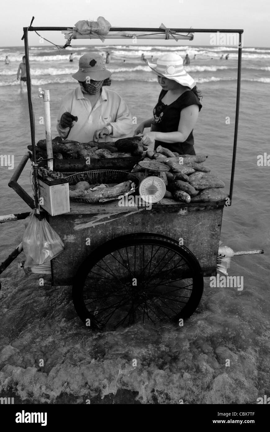 Vungtau, Vietnam. Anbieter verkaufen gegrillte Süßkartoffeln am Strand. Stockfoto