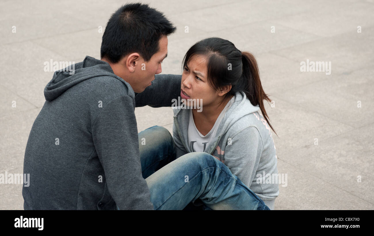 Taiyuan, China. Junges Paar sitzt auf dem Platz vor dem Bahnhof von Taiyuan. Stockfoto
