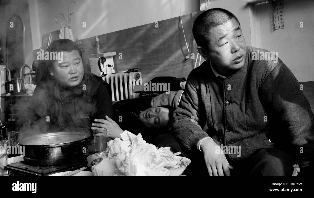 Gaobeidian, Beijing. Männer, die ein Eintopf Mittagessen und Getränke mit Freunden an einem Vogel Shop. Stockfoto