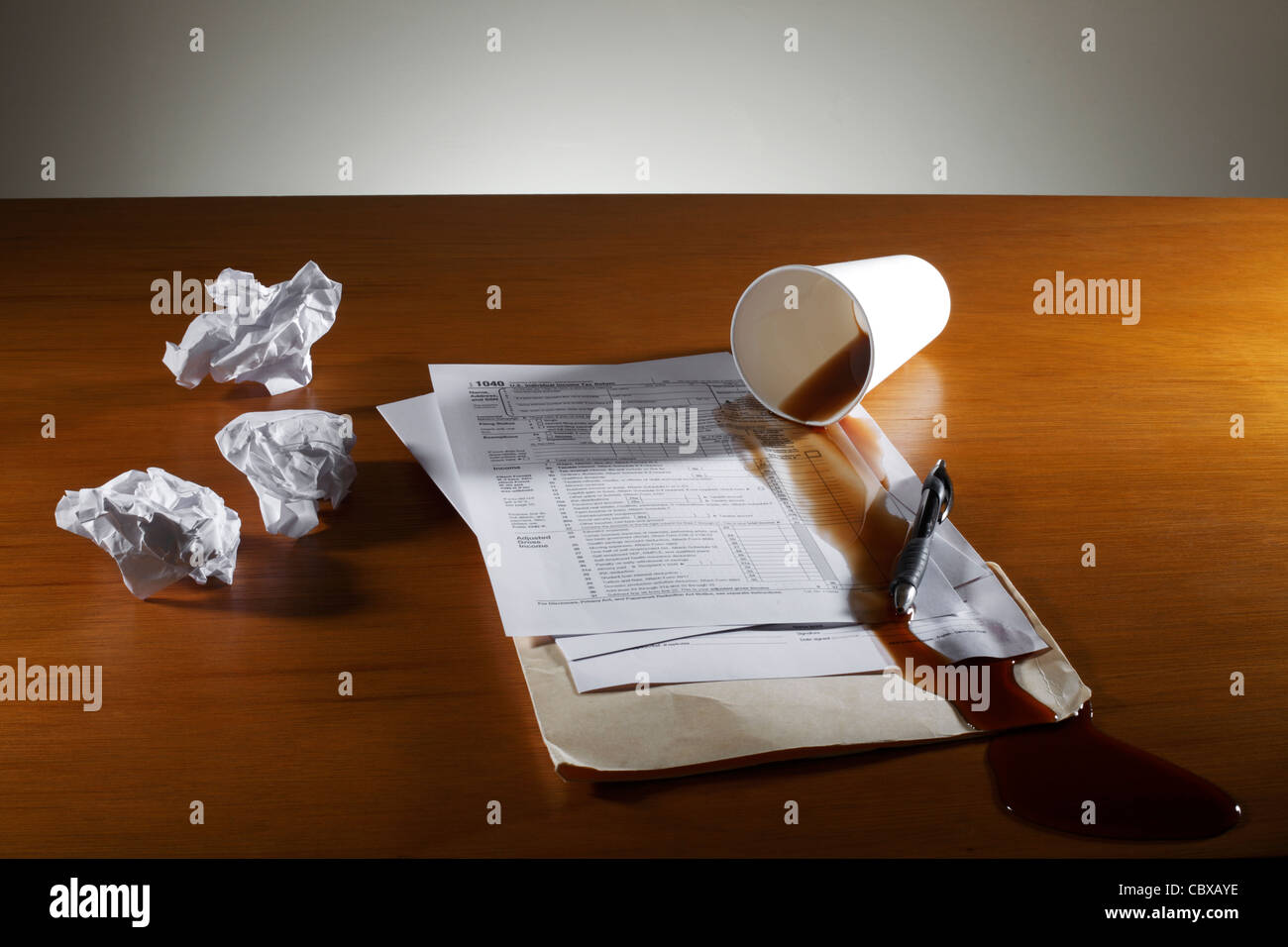 Zerknittertes Papier verschüttet Kaffee und Steuer Formular auf Schreibtisch Stockfoto