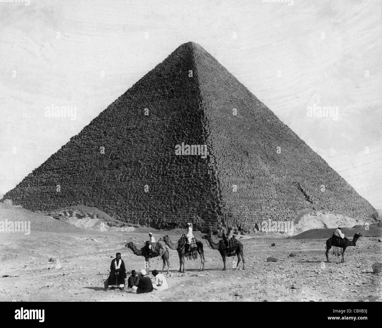 Ägyptische Männer in der Nähe der Basis der großen Pyramide, einige auf Kamel zurück, um 1890 Stockfoto