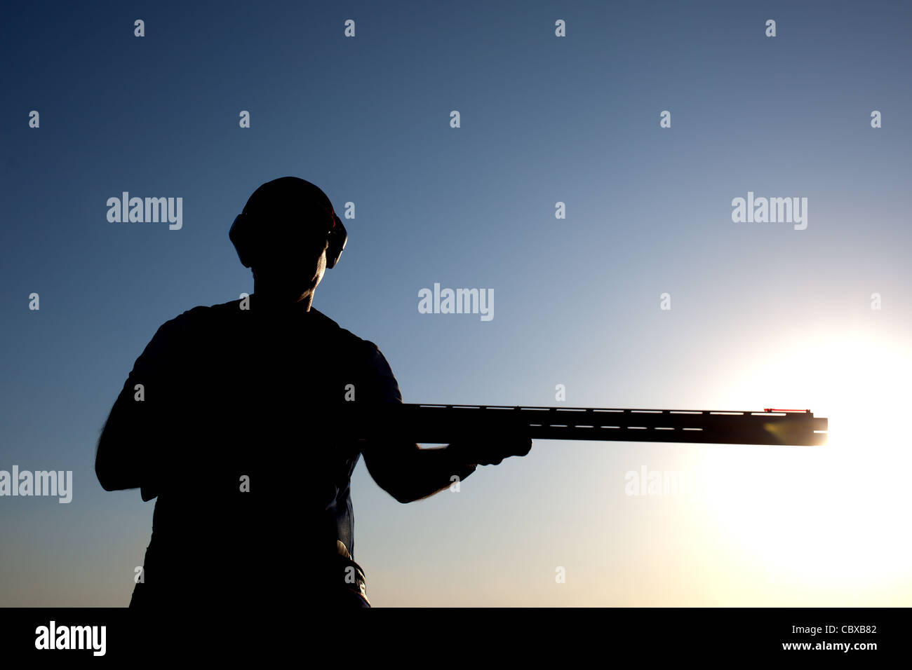 Mann-Vorbereitung für das Schießen mit seiner Pistole silhouette Stockfoto