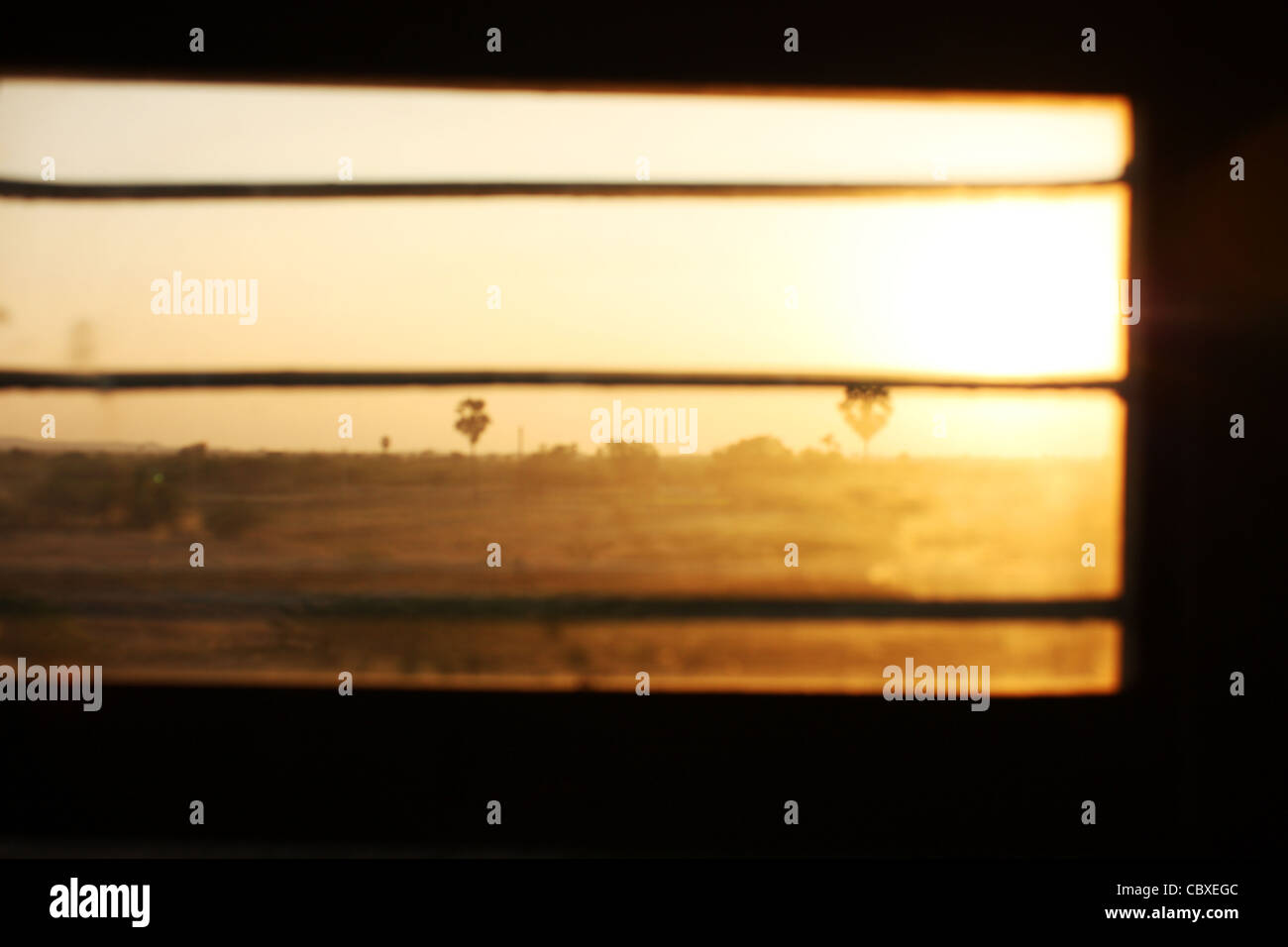 Ansicht einer untergehenden Sonne durch ein indischer Zug Fenster. Dieses Bild wurde gefangen genommen, während der Reise durch Rajasthan. Stockfoto