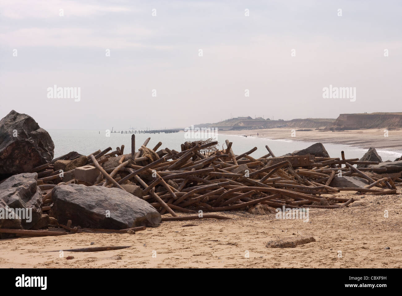 Happisburgh Küste, North Norfolk. Erodiert und zerstörten Metall Brakewaters angesammelt am Strand. Stockfoto
