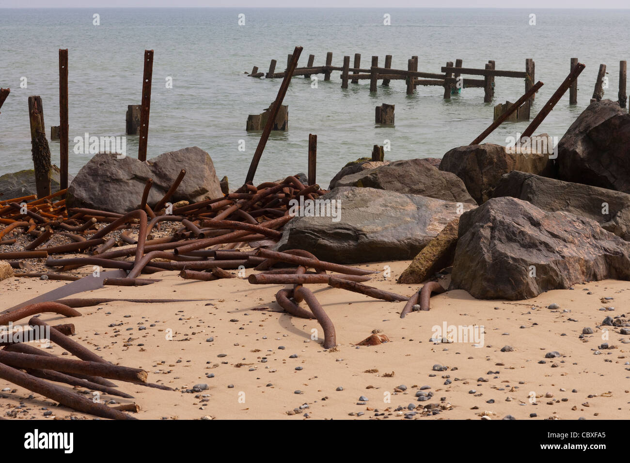 Happisburgh Beach, North Norfolk. Holz und Metall Brakewaters mit importierter Granitfelsen, in der Lage, Meer mildern zerstört Stockfoto